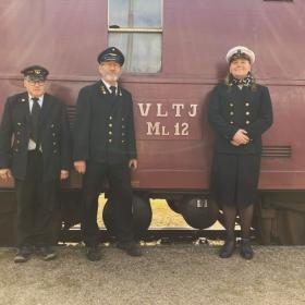 Lokomotivfører, togfører og stationsansvarlig står foran toget